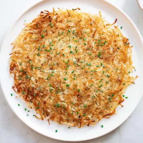Crisp shredded Hash Browns with a savory onion flavor, prepared in a nonstick pan for a perfect golden sear.