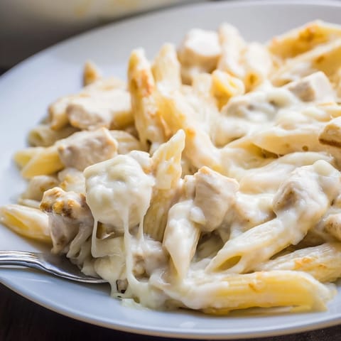 Tender chicken and penne pasta coated in creamy ranch sauce, ready to serve for a family dinner.