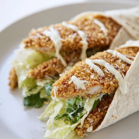 Freshly grated Parmesan and Caesar sauce coat crispy chicken inside a warm wrap, paired with crunchy lettuce for a satisfying bite.