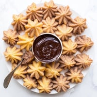 Golden-brown homemade churros, coated in cinnamon sugar and drizzled with chocolate sauce.