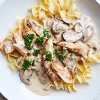 Golden-brown chicken strips and sautéed cremini mushrooms rest in a creamy, paprika-scented sauce over tender egg noodles for this comforting Chicken and Mushroom Stroganoff.