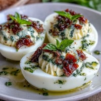 Caprese Deviled Eggs: a vibrant appetizer with creamy filling and fresh tomato garnish.